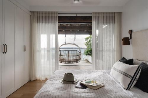 a bedroom with a bed with a hat and books at Bay Properties Bridgewood in Yamba