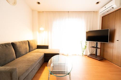 a living room with a couch and a glass table at Yotsugi House 3rd Floor - Prime Location Near Asakusa and Skytree in Tokyo