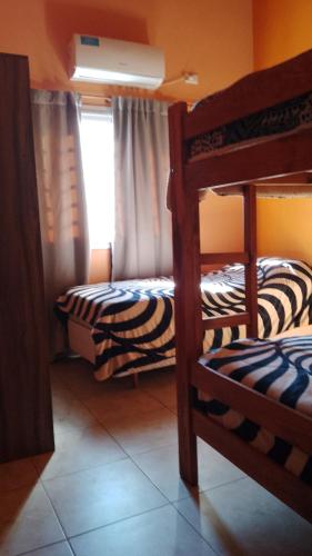 two bunk beds in a room with a window at Complejo Aura in Colón