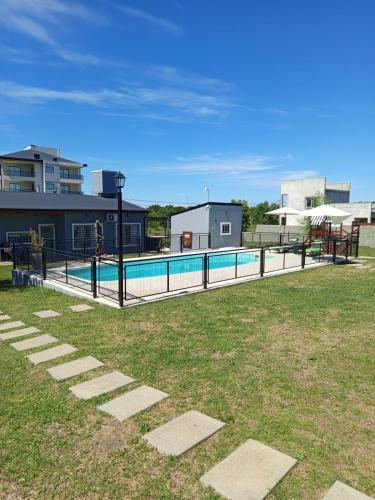 a swimming pool in a yard with a playground at Complejo Aura in Colón
