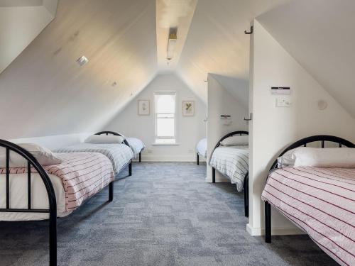 a row of beds in a room with a window at The Fenway Hostel in Launceston
