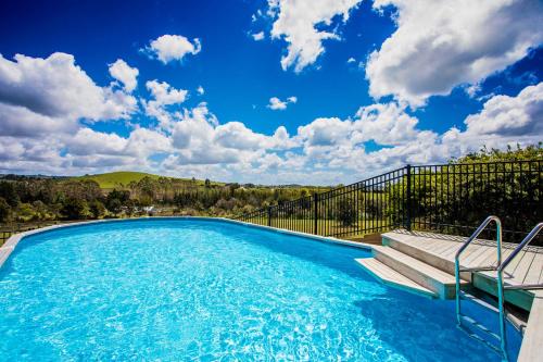 a swimming pool with a bench and a blue sky at The Shack in Mangonui