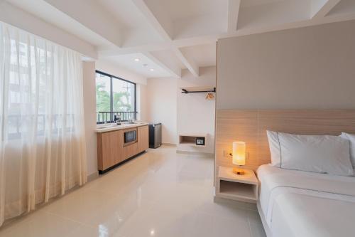a bedroom with a bed and a bathroom with a sink at Alcaré Rooms Cartagena in Cartagena de Indias