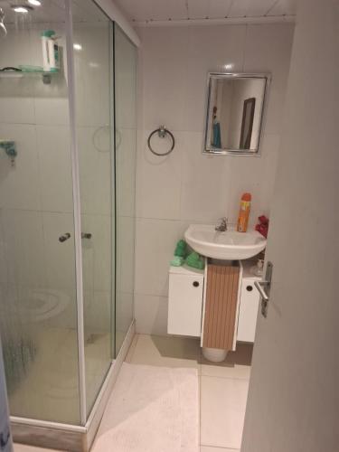 a bathroom with a shower and a sink at Casas do Pescador in Maricá