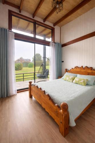 a bedroom with a wooden bed and a large window at Refugio Matteo&Colo Sur de Chile in Panguipulli