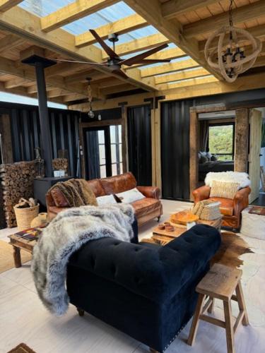 a living room with a blue couch and a table at Rangitoto Retreat Raglan in Te Akau