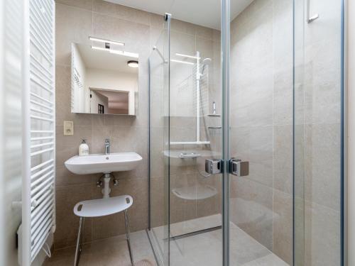 a bathroom with a glass shower and a sink at Aperol Spritz in Zutendaal