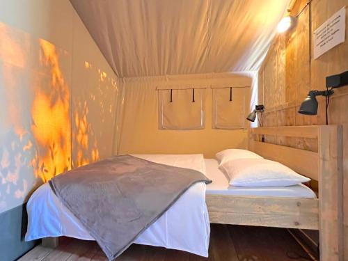 a bedroom with a bed in a small room at De Mier in Hulshorst