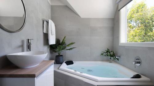 a bathroom with a tub and a sink and a window at Kingfisher Loft in Daylesford