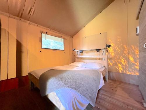 a bedroom with a bed in a room with a window at de Krekel in Hulshorst