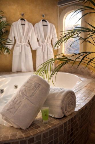 a bathroom with a bath tub with towels and a mirror at Nequi Hotel Boutique in Tepoztlán