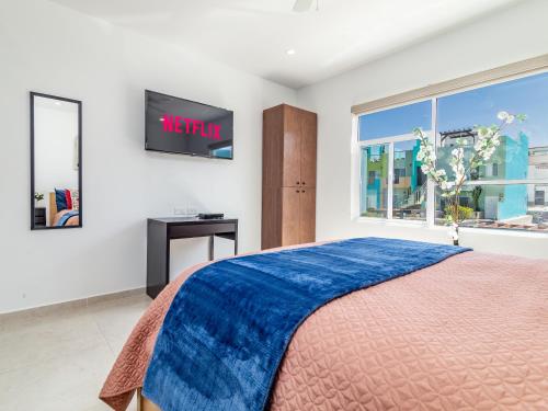 a bedroom with a bed and a tv on a wall at Ocean View, Amazing Sunsets, AC, Pool in Tijuana