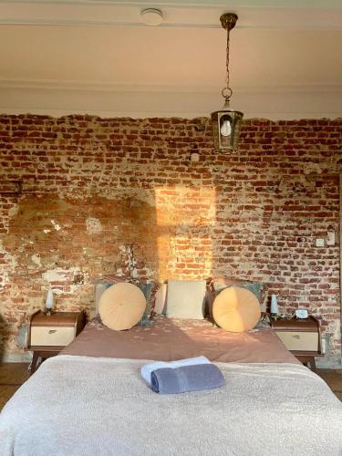 a bed in a room with a brick wall at Gîte La Cure in Noduwez