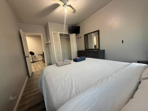 a bedroom with a white bed and a ceiling fan at EWRBNB- Private bedroom in a Well Spaced Shared Apartment 4 in Elizabeth
