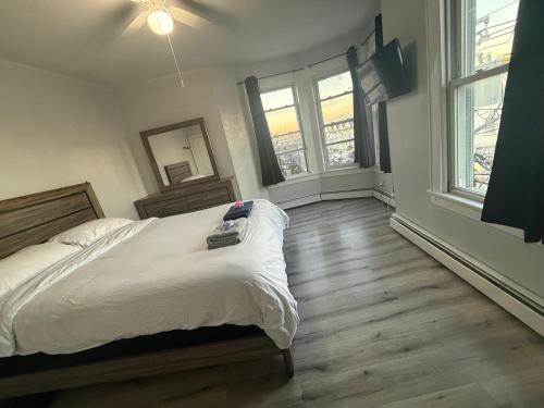 a bedroom with a bed and two windows at EWRBNB- Private bedroom in a Well Spaced Shared Apartment 4 in Elizabeth