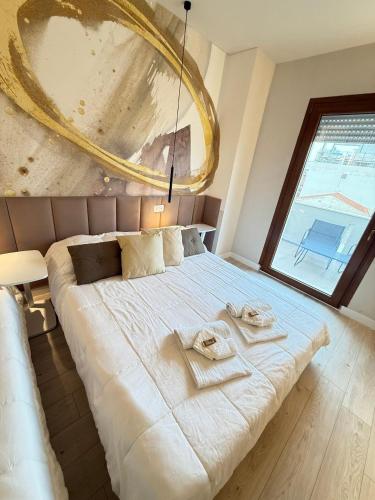a bedroom with a large bed with towels on it at La suite N4-elegant suite near lido beach in Alghero