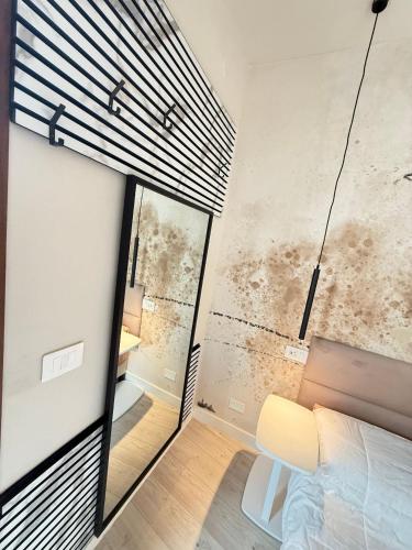 a bedroom with a mirror and a bed and a window at La suite N4-elegant suite near lido beach in Alghero