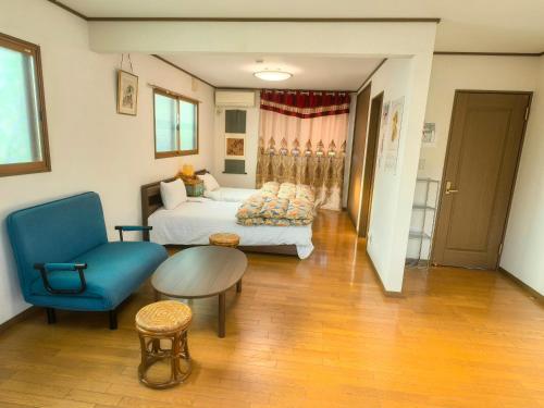 a bedroom with a bed and a blue chair at 温泉郡宿 in Toon