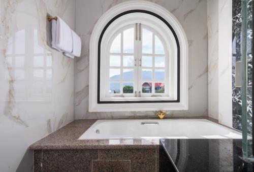 a bath tub in a bathroom with a window at Swiss-Belexpress Palu in Palu