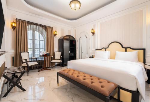 a bedroom with a large bed and a dining room at Swiss-Belexpress Palu in Palu