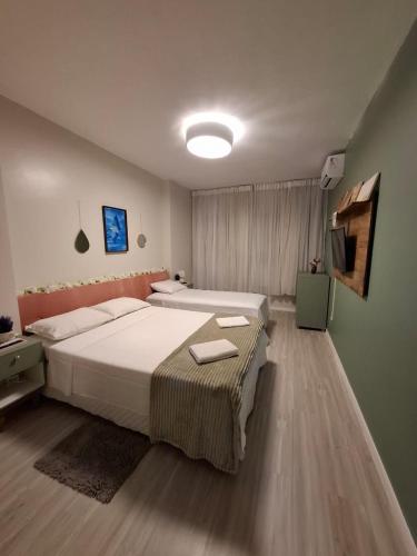 a large bedroom with two beds and a television at Flat com Vista Teatro Amazonas in Manaus