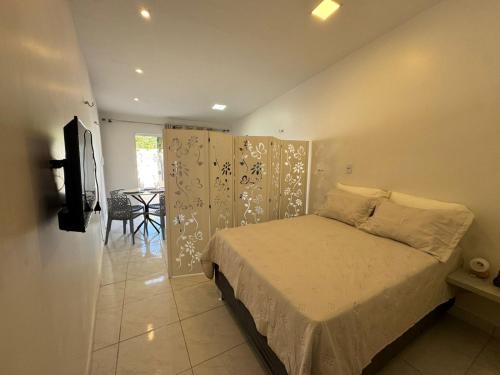 a bedroom with a bed in a room with a table at Casa aconchego do pontal in Fortim