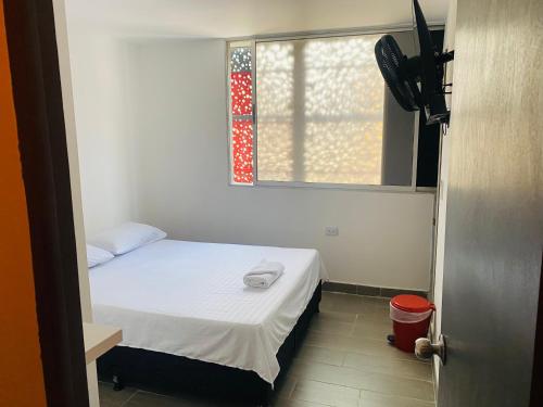 a small room with a bed and a window at Hotel sahara in Medellín