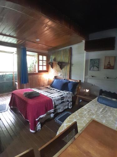 a bedroom with a bed and a couch in a room at Chalé Bambu in Cunha
