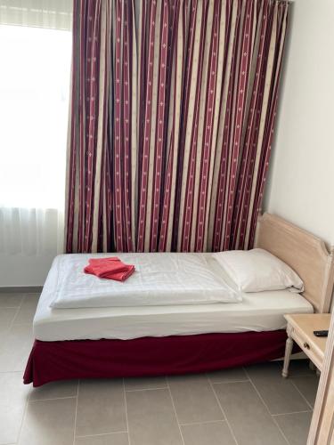 a bed in a room with a red shirt on it at Pension-Wob 2 in Wolfsburg