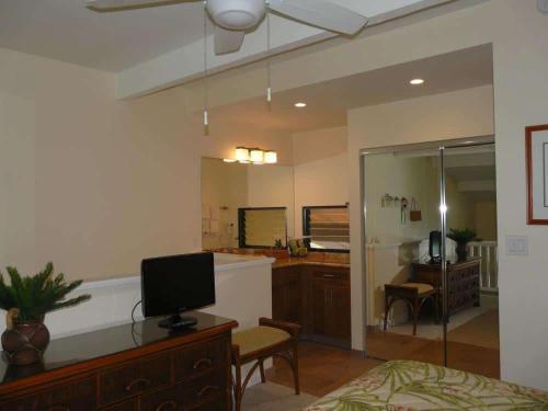 a bedroom with a bed and a desk with a television at Peaceful Ocean-View 2BR Loft Escape - Unit C38 condo in Lahaina