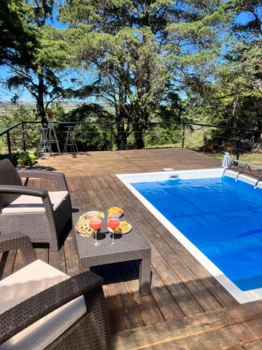 a patio with a pool and a table with drinks at NuestroSueño in Villa Serrana