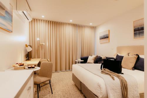 a hotel room with a large bed and a couch at Punthill Williamstown in Williamstown