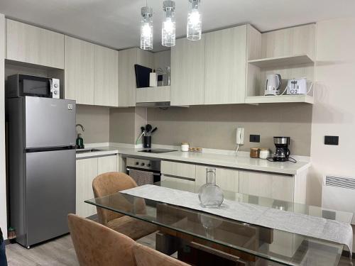 a kitchen with a glass table and a refrigerator at Puerto Montt centro 2 diagonal Germania in Puerto Montt