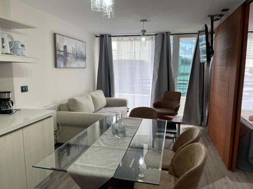 a kitchen and living room with a glass table at Puerto Montt centro 2 diagonal Germania in Puerto Montt
