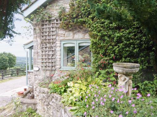 a stone house with a window and flowers at The Pigsty Cottage E2783 in Oswestry