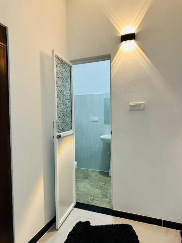 a bathroom with a door leading to a bathroom with a sink at KOKO Villa in Kochchikade