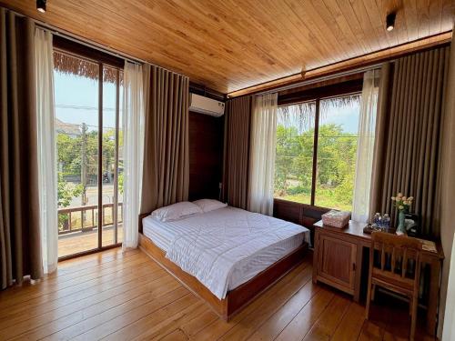 a bedroom with a bed and a large window at Moc Homestay & Villa in Cư Chinh