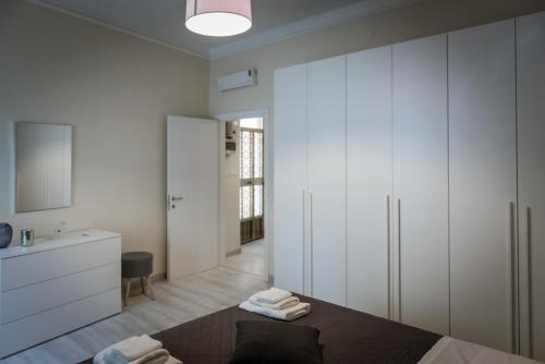 a bedroom with a bed with white cabinets and a bathroom at Casa FONTE GRANDE a due passi dalla Clinica "Immacolata" in Celano