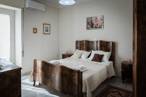 a bedroom with a bed with a wooden headboard at Casa FONTE GRANDE a due passi dalla Clinica "Immacolata" in Celano