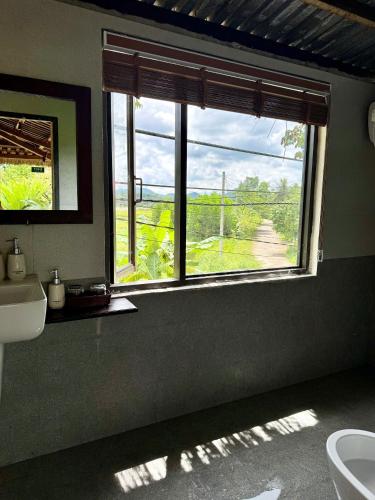 a bathroom with a sink and a window with a view at Moc Homestay & Villa in Cư Chinh