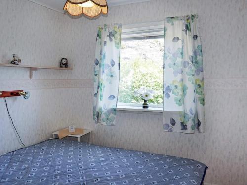 a bedroom with a bed and a window with curtains at Comfortable Apartment Near Stenungsund in Munkedal