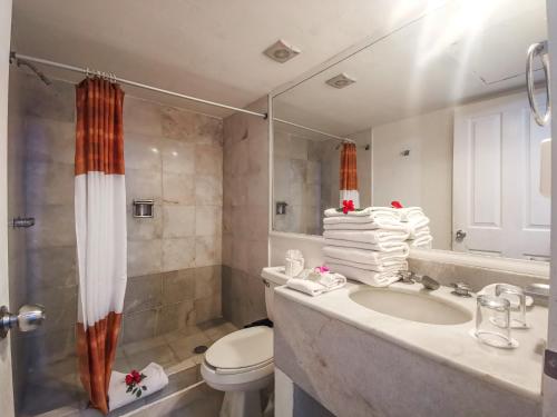 a bathroom with a toilet and a sink and a shower at Condominios Torre Continental Ixtapa in Ixtapa