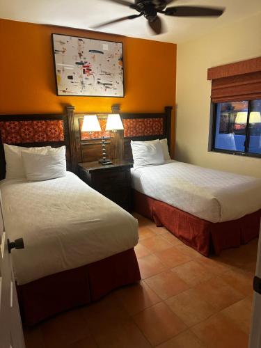 a hotel room with two beds and a ceiling fan at La Paloma in Rosarito Beach
