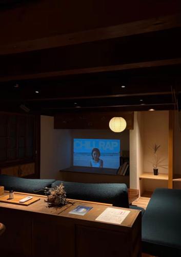 a room with a table and a tv in the background at 帰々Kiki in Yamatokoriyama