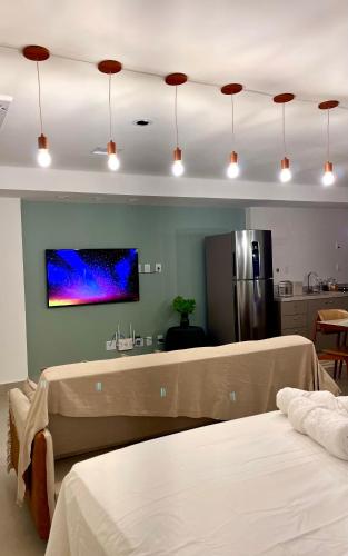 a room with two beds and a kitchen with a refrigerator at Azure Aesse Hospitality Marista in Goiânia