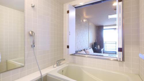 a white bathroom with a tub and a mirror at Shoji Mount Hotel - Vacation STAY 83000v in Narusawa