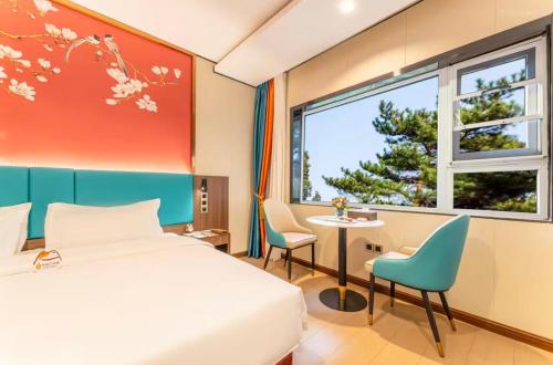 a bedroom with a bed and a table and a window at 济南璞秀酒店-山东师范大学千佛山店Cultural Experience Hotel in Jinan