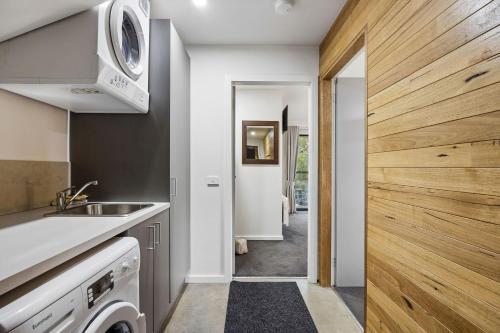 a kitchen with a sink and a washing machine at Roses Creek Chalet B in Crackenback