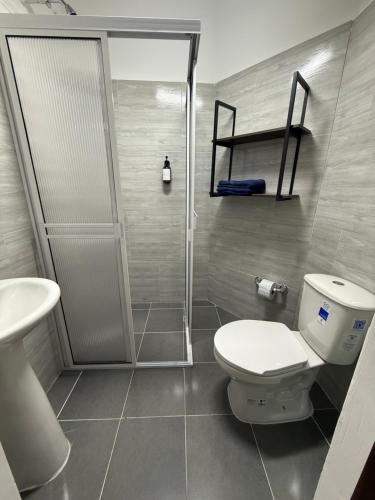 a bathroom with a shower and a toilet and a sink at Hostal Casablanca in San Gil