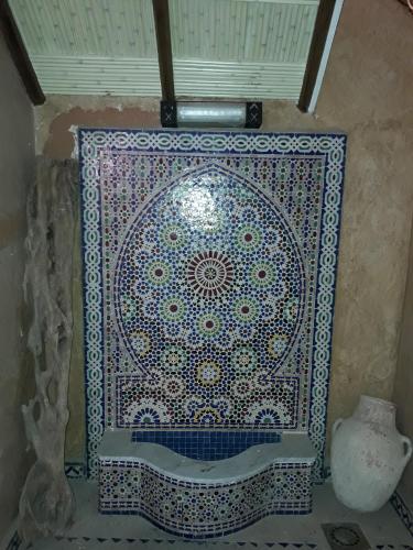 a mosaic tile on the wall of a bathroom at Hotel Salama STE SAL- AMA SUD SARL AU in Tafraout